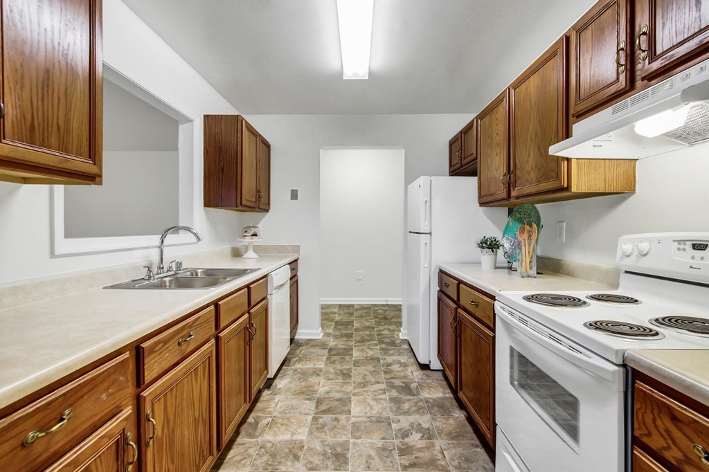 A kitchen with wooden cabinets and a white refrigerator.