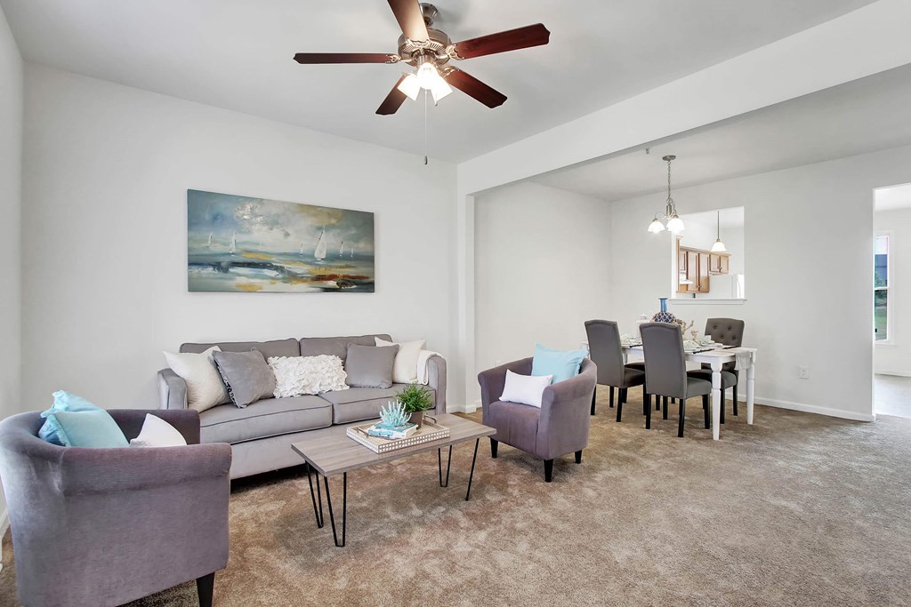 A living room with a grey couch, a coffee table, and a painting on the wall.