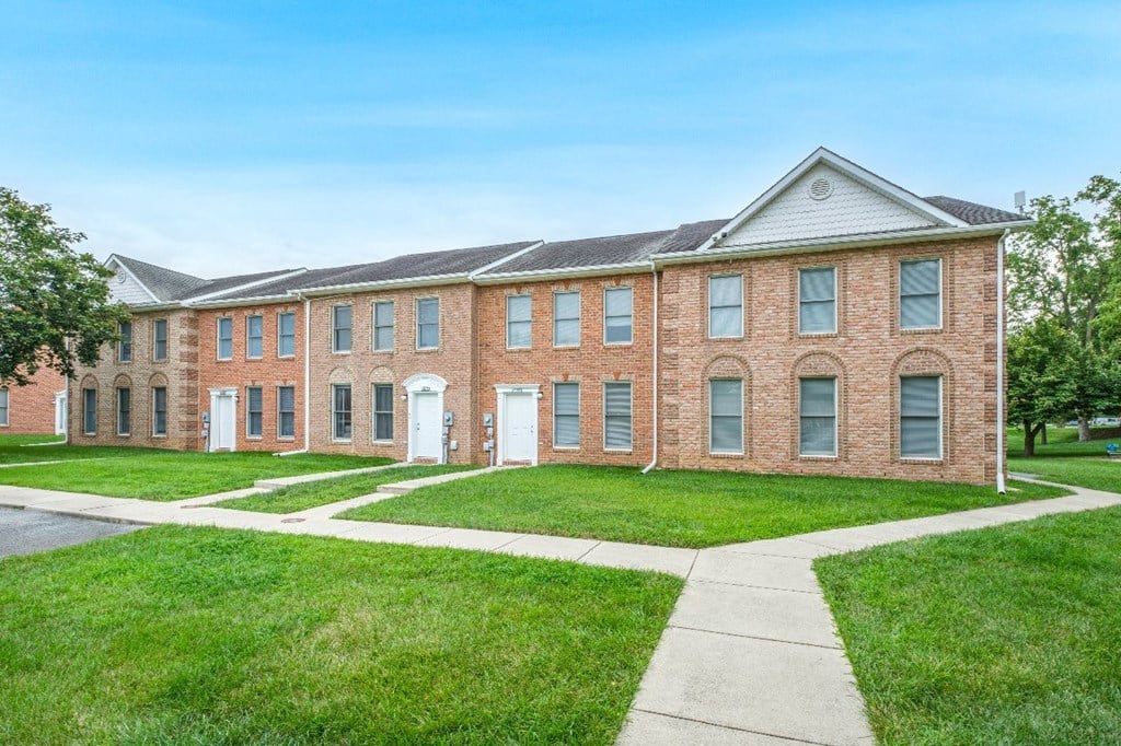 A large red brick building with a white door and windows.