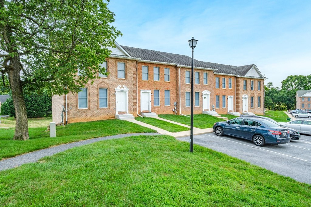 A red brick building with a white door and windows.