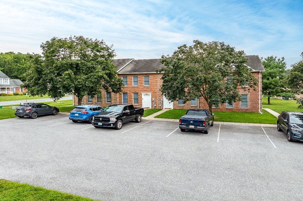 A parking lot with cars and a building in the background.