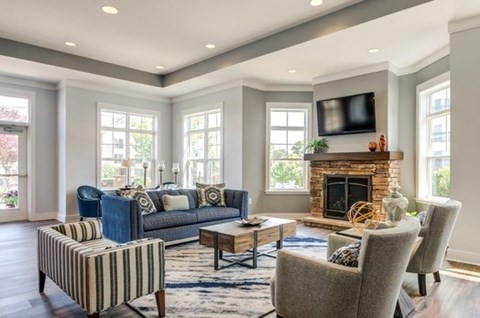 A living room with a fireplace and a television on the wall.