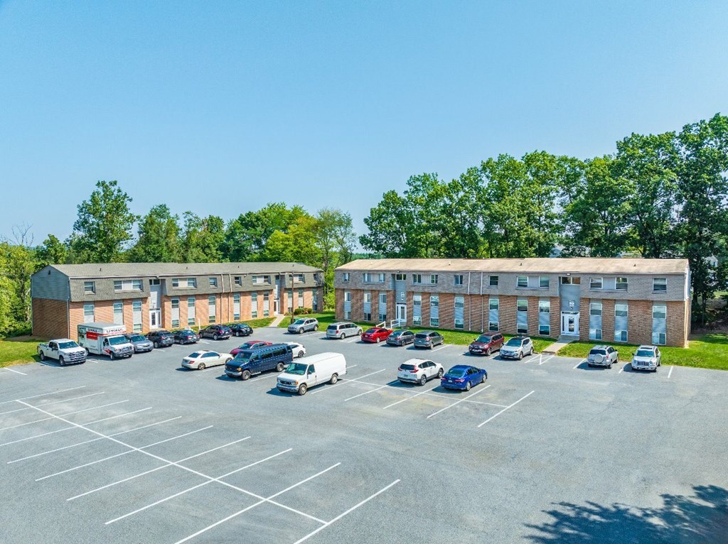 A parking lot with cars and a building in the background.
