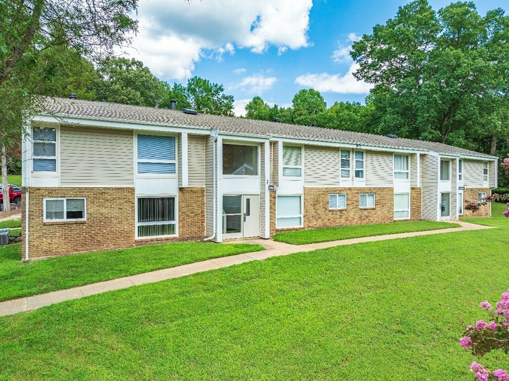 A row of houses with green lawns in front.