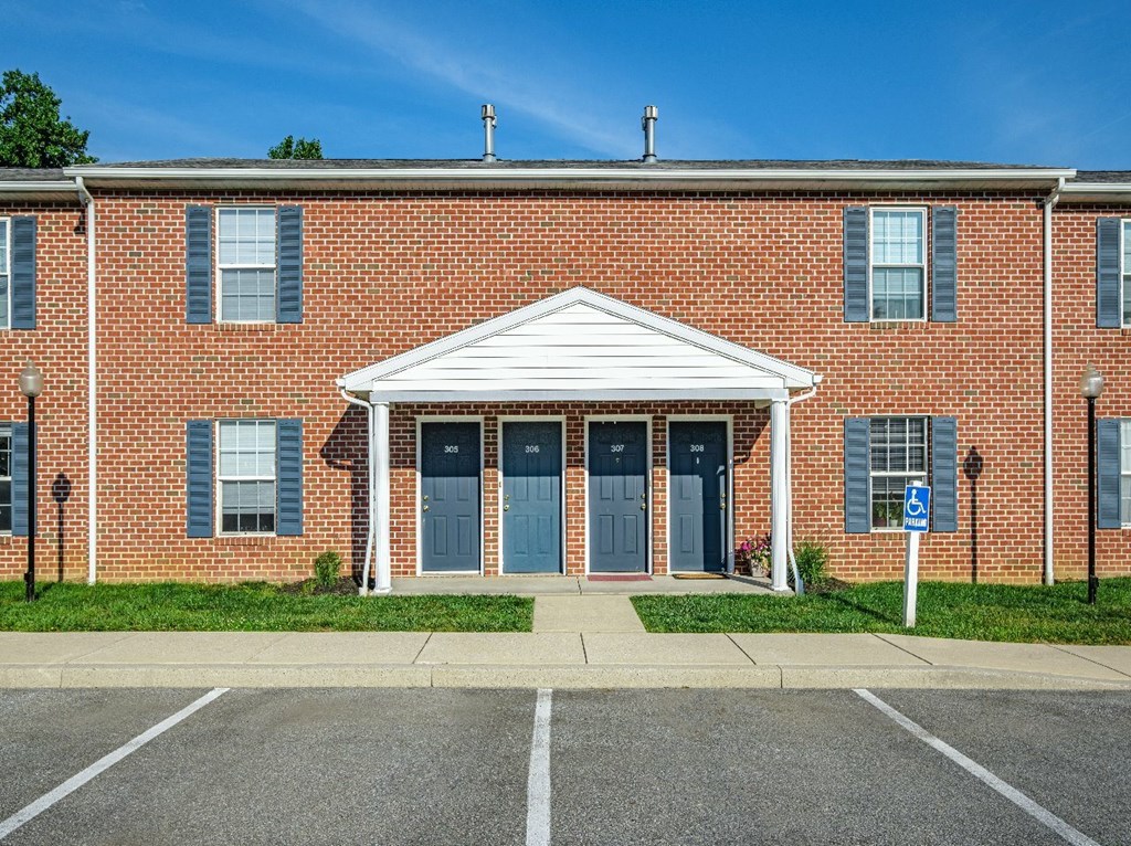 A red brick building with a white canopy and a blue sign on the right.