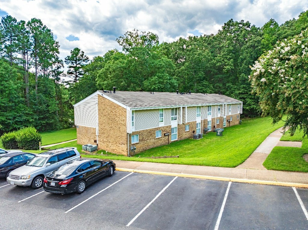 A parking lot with cars and a building in the background.