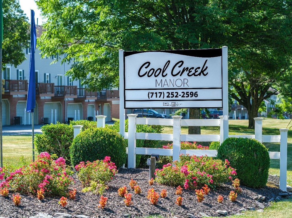 A sign for Cool Creek Manor with a phone number on it.