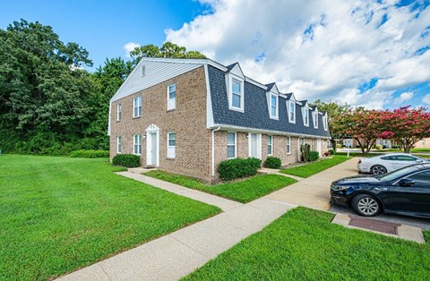 A brick house with a white door and windows.