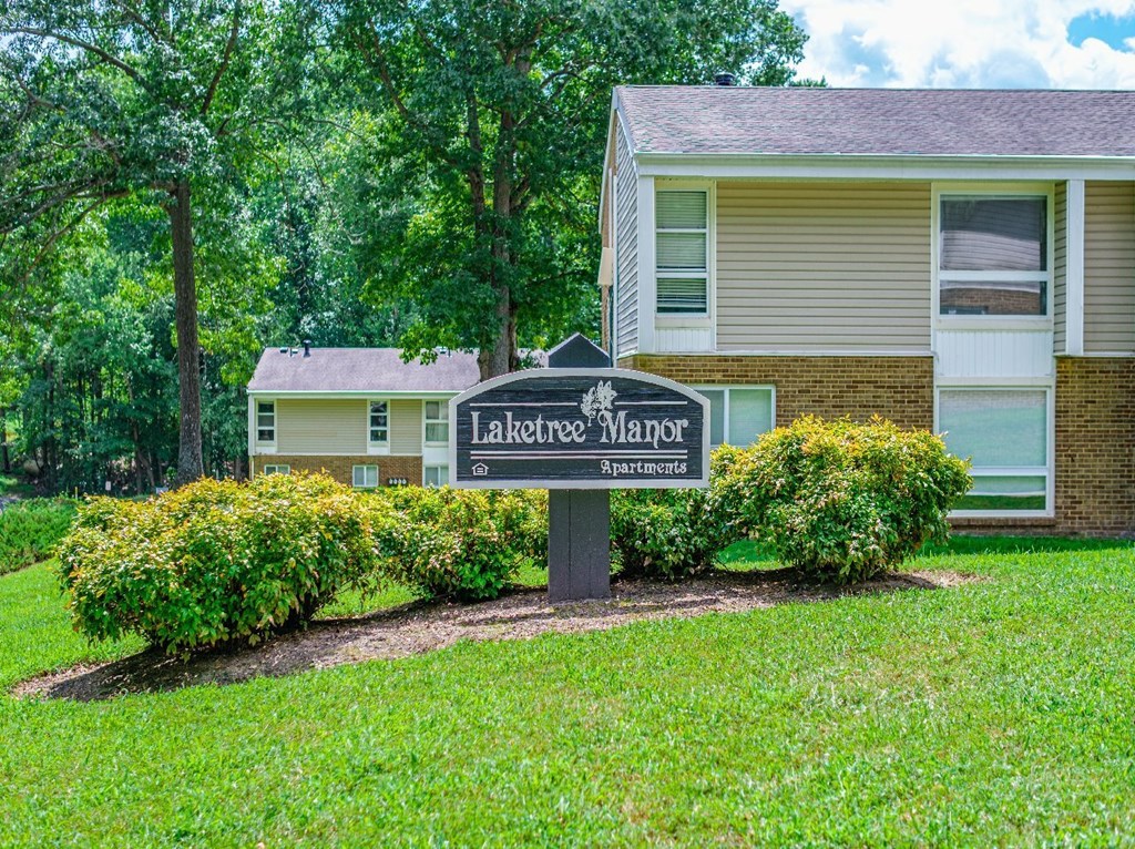 A sign for Lakeview Manor Apartments stands in front of a building.