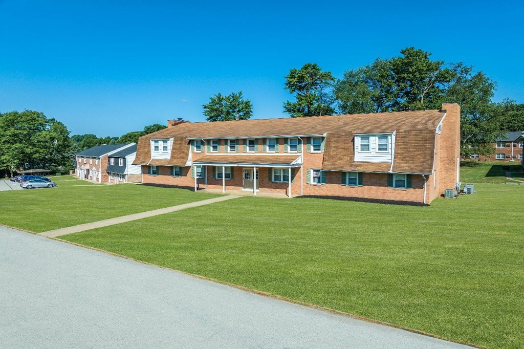 A large building with a parking lot in front.