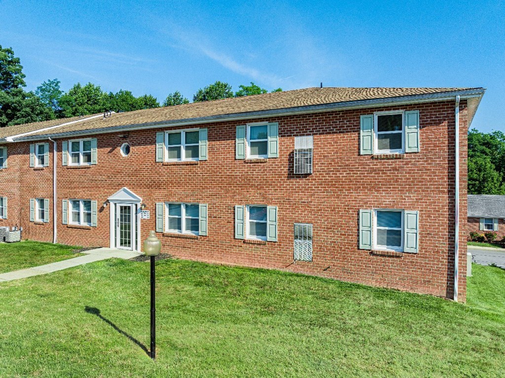 A red brick building with a white door and windows.