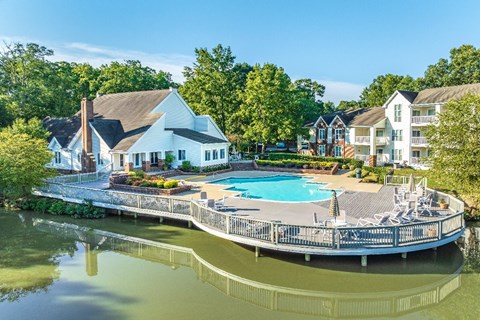 A large house with a pool is surrounded by trees.
