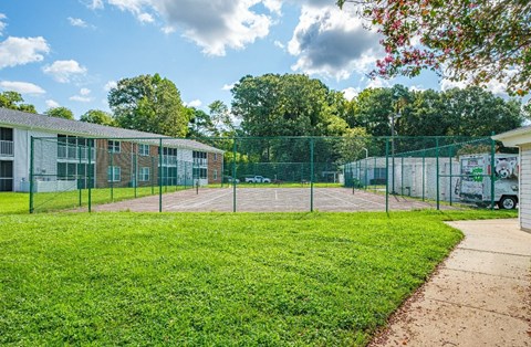 A green fenced area with a building in the background.