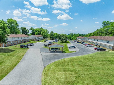 A sunny day at a park with a playground and a winding road.