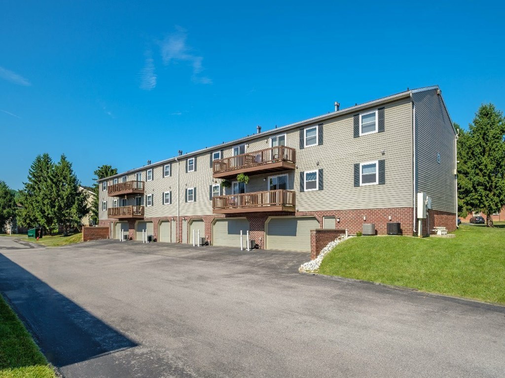 A multi-story apartment building with a parking lot in front.