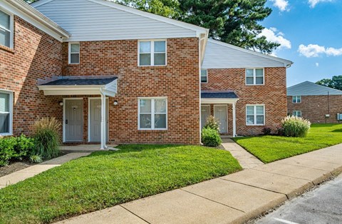 A brick house with a white door and windows.