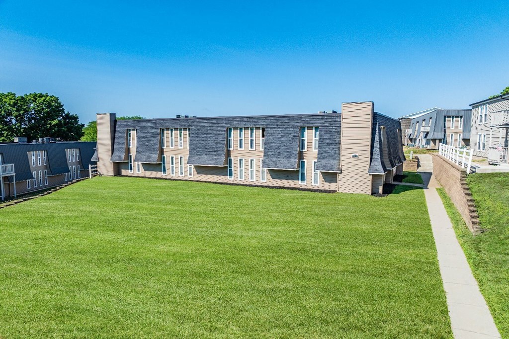 A row of houses with a green lawn in front.