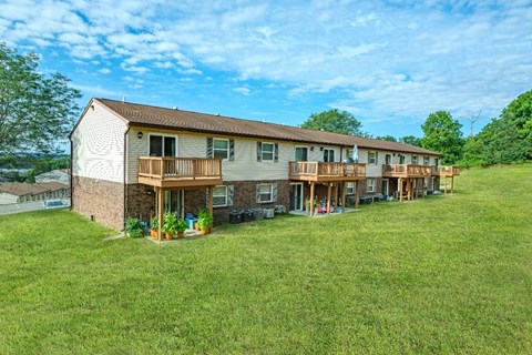 A long building with a balcony and a brown roof.