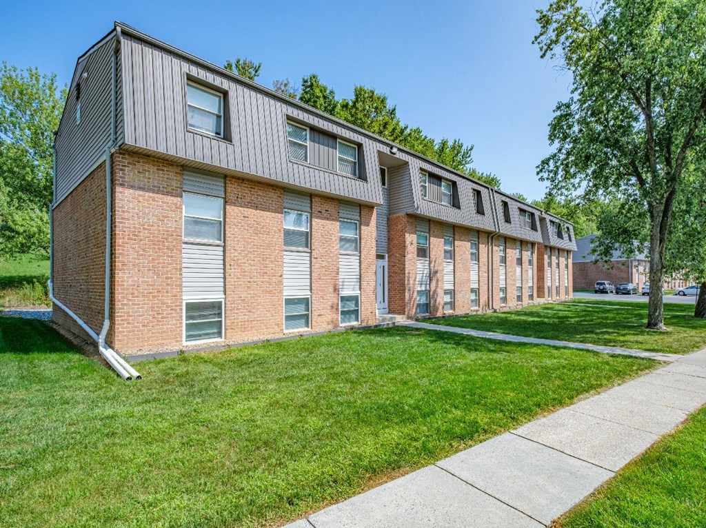 A long building with a grey roof and red brick walls.