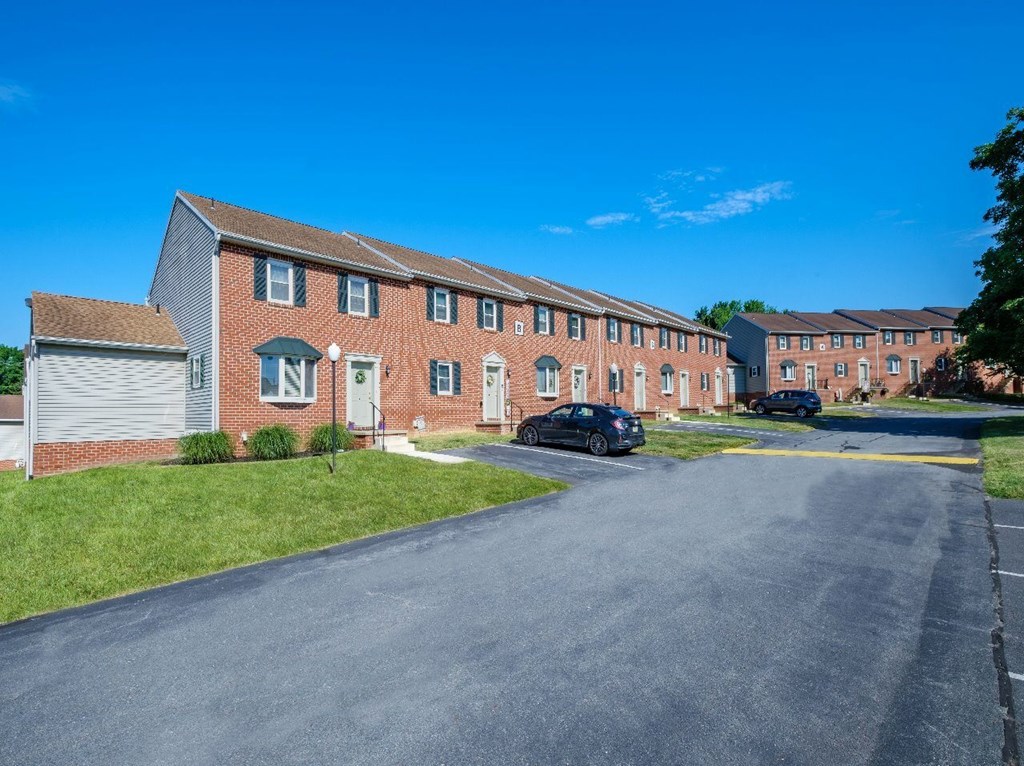 A long brick building with a white door and windows.