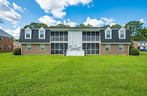 A large house with a white porch and a balcony.