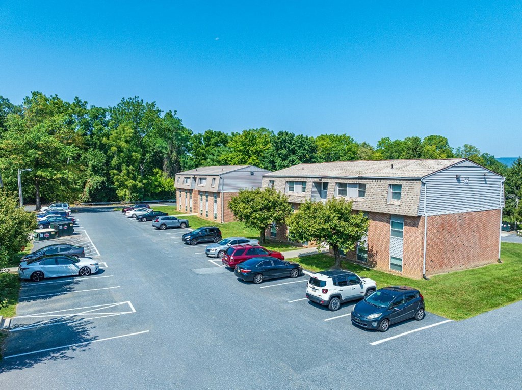 A parking lot with cars and a building in the background.
