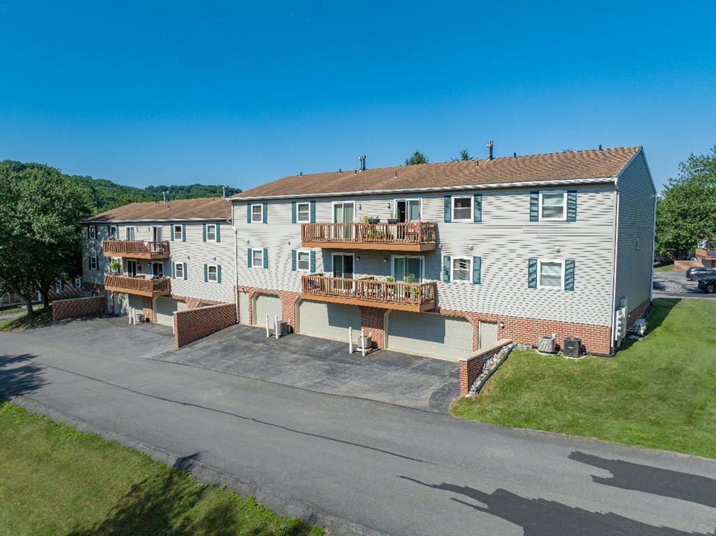 A large two-story apartment building with a parking lot in front.