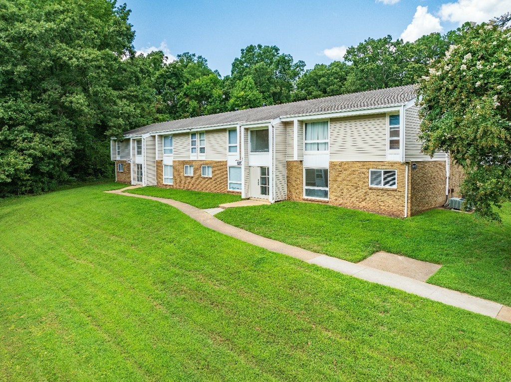 Apartment building with a green lawn in front.
