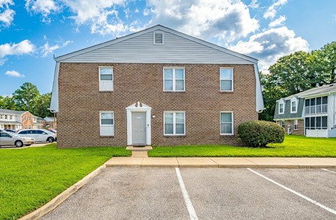 A two-story brick house with a white door and windows.