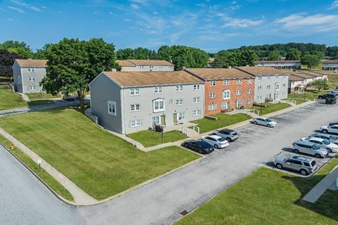 A parking lot with cars and apartment buildings in the background.