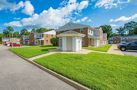 A sunny day at a residential area with houses and cars.