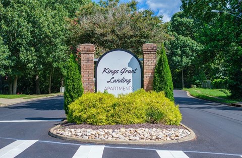 A Kings Grant Landing Apartments sign is in front of a road.