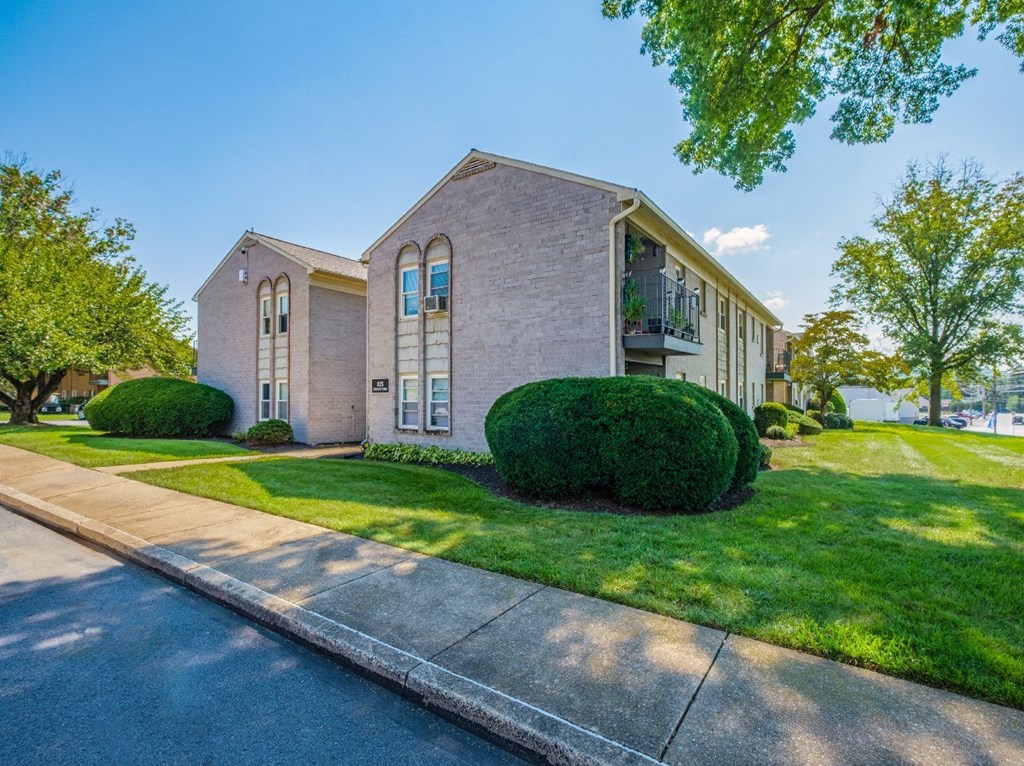 A house with a well-manicured lawn and a clear sky above.