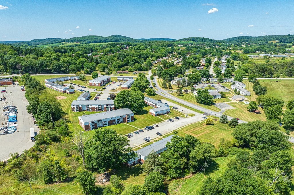 An aerial view of a large building surrounded by trees and a parking lot.