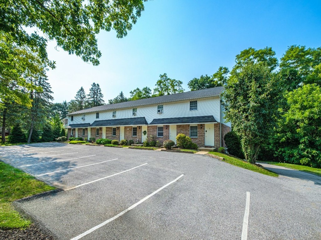 A white building with a parking lot in front of it.