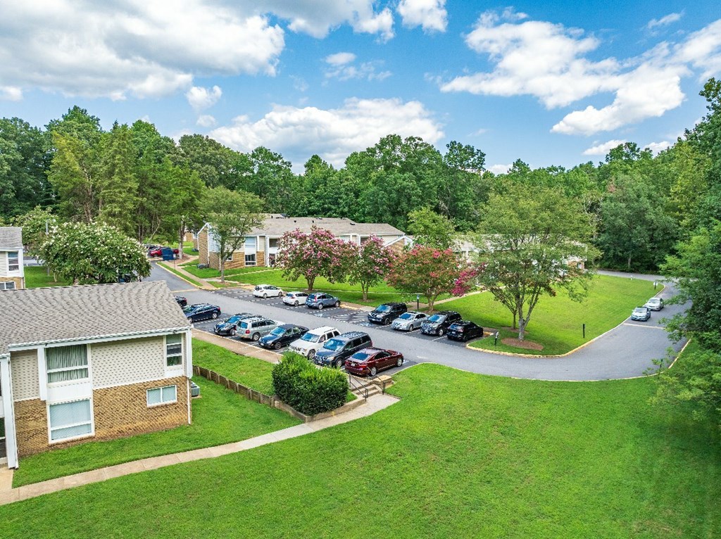 A parking lot with cars and a building in the background.