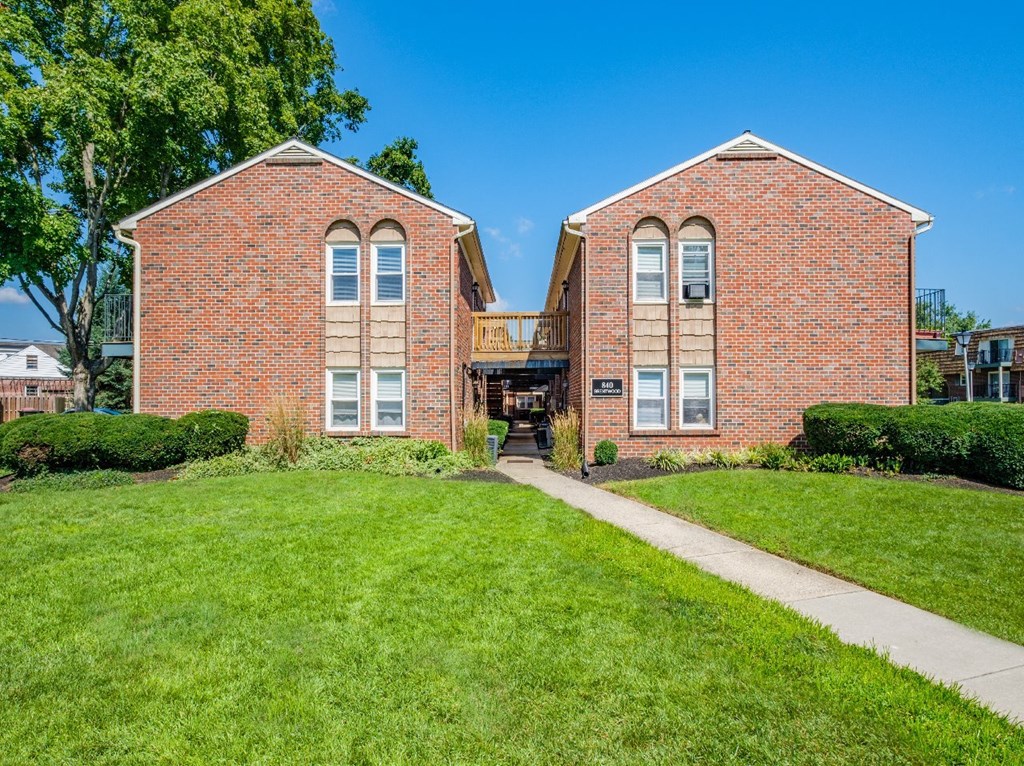 A red brick building with a balcony in the middle.