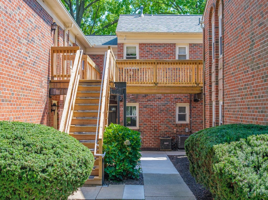 A wooden staircase with a railing leads to a balcony.