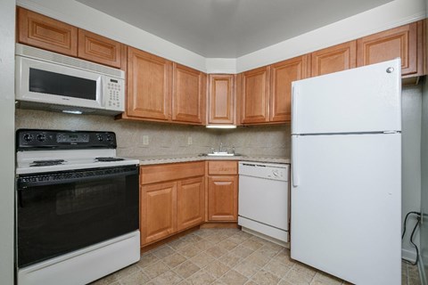 A kitchen with wooden cabinets and a white refrigerator.