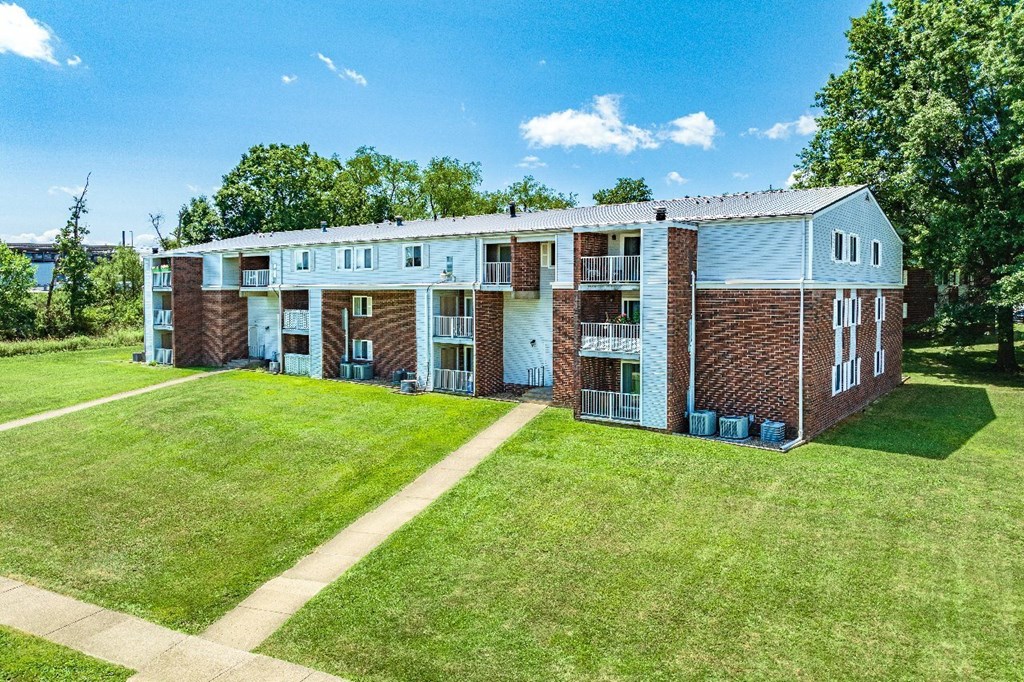 A large apartment complex with a green lawn in front.