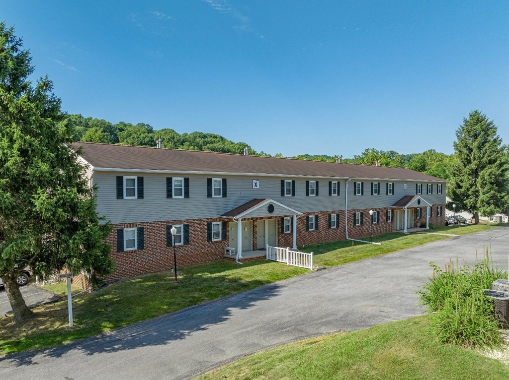 A long building with a white picket fence in front.