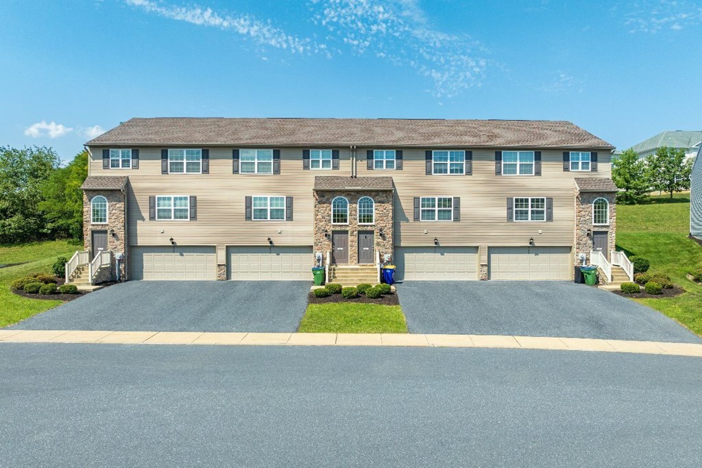 A large house with a driveway in front.
