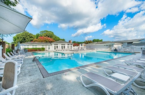 A large outdoor swimming pool surrounded by sun loungers.