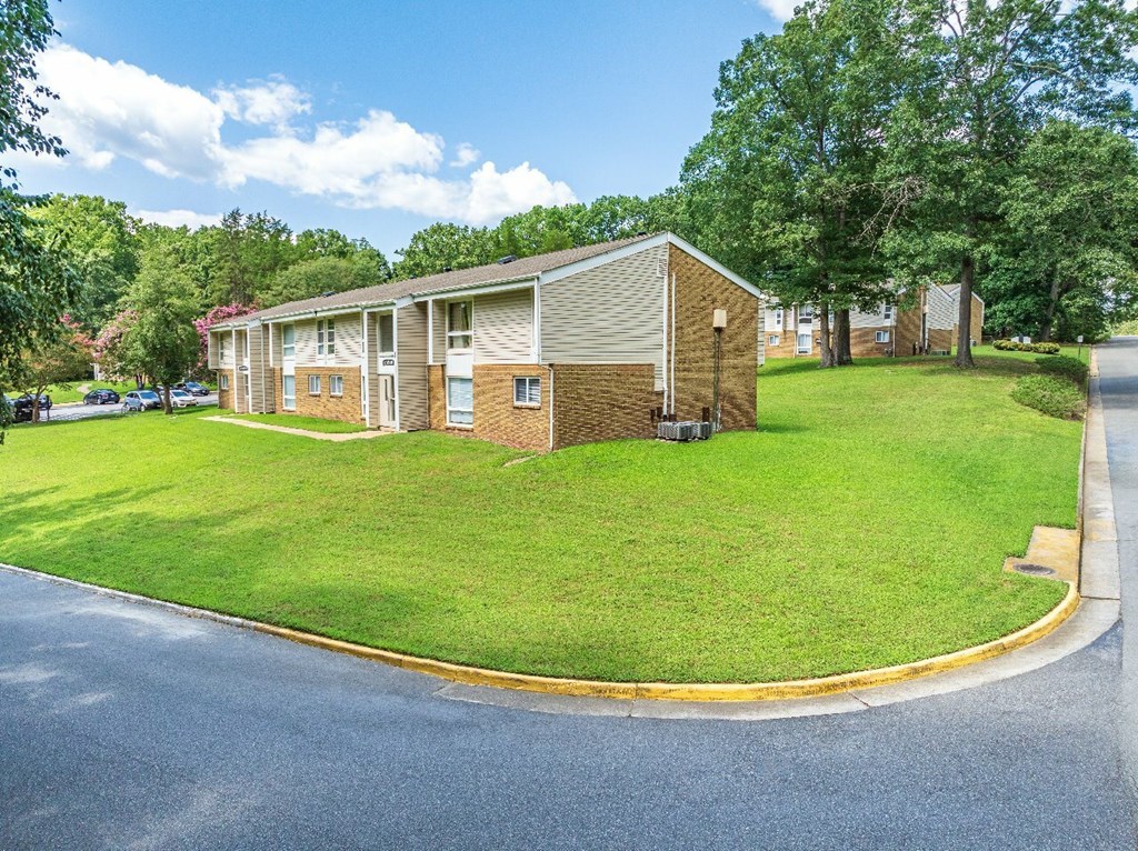 A small building with a yellow line around it is in the middle of a grassy area.