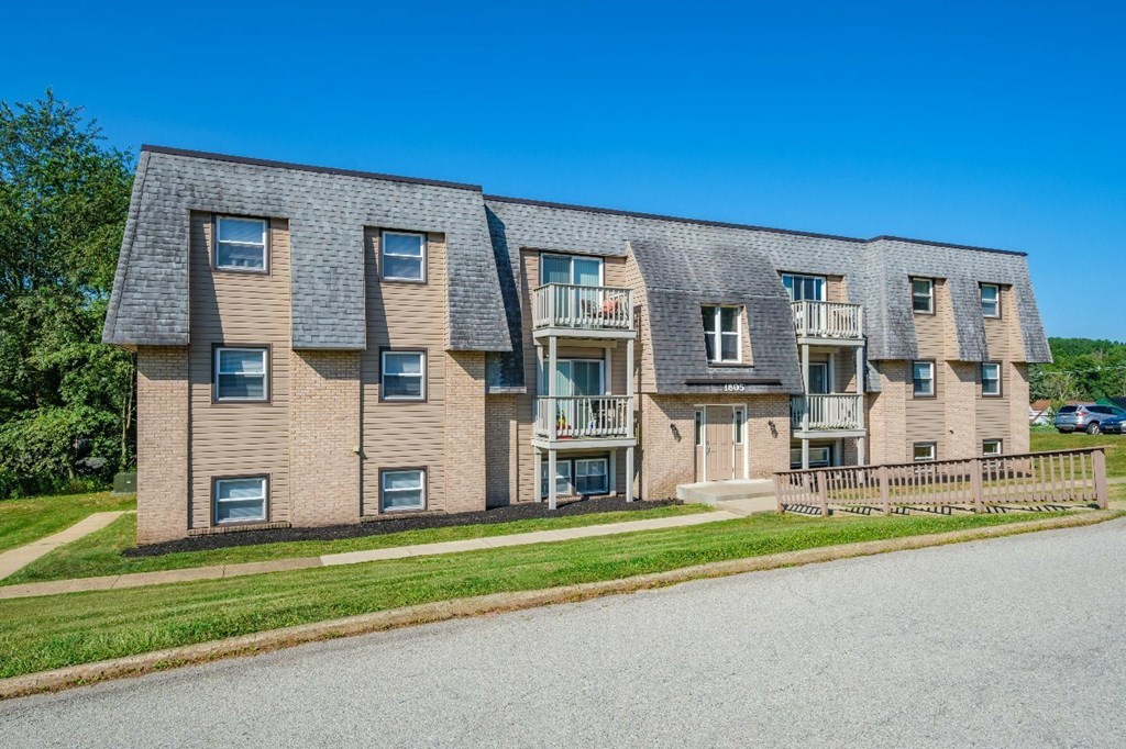 A row of townhouses with a clear blue sky above.