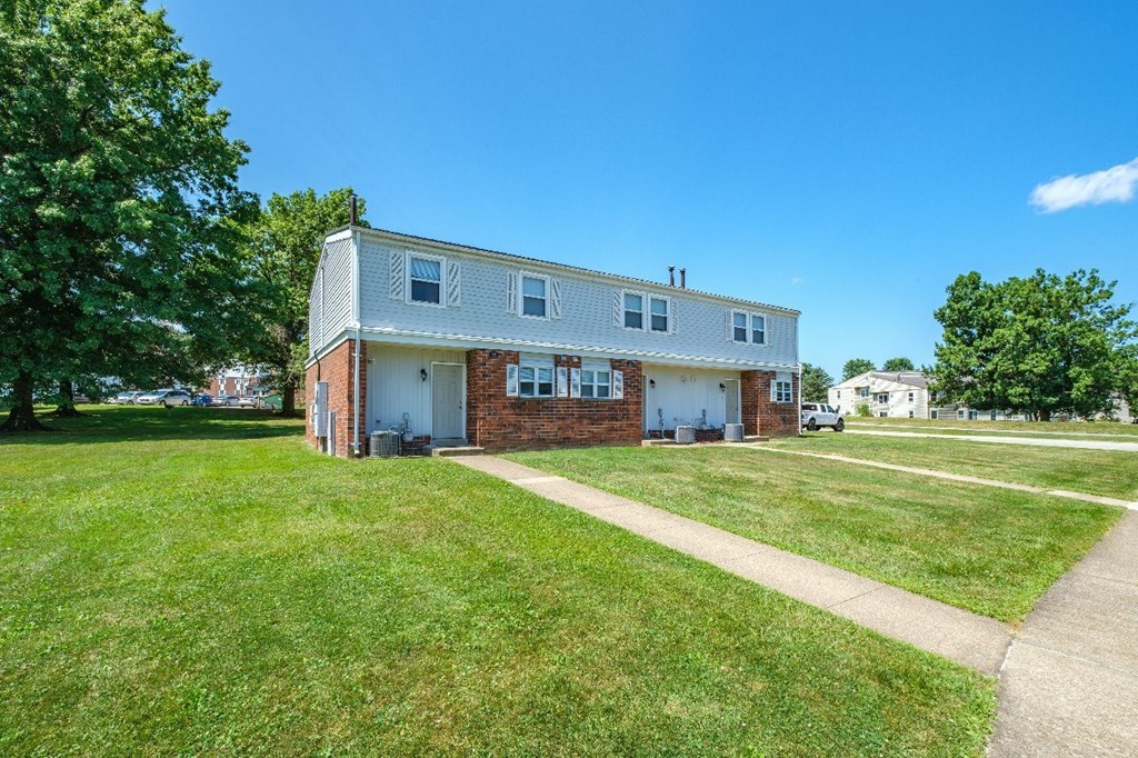 A two-story house with a white garage door and a brick facade.