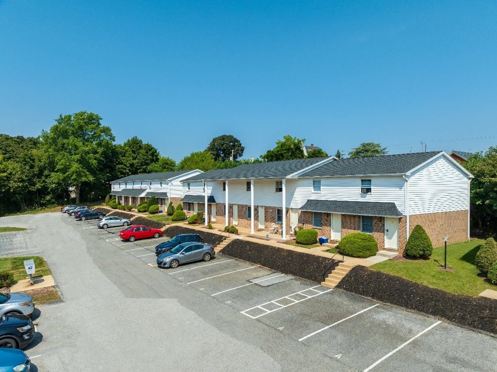 A parking lot with cars and a building in the background.
