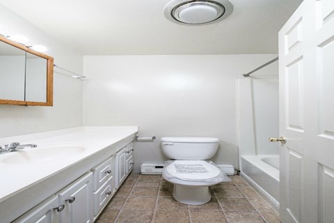 A white toilet with a white sink and a white bathtub in a bathroom.