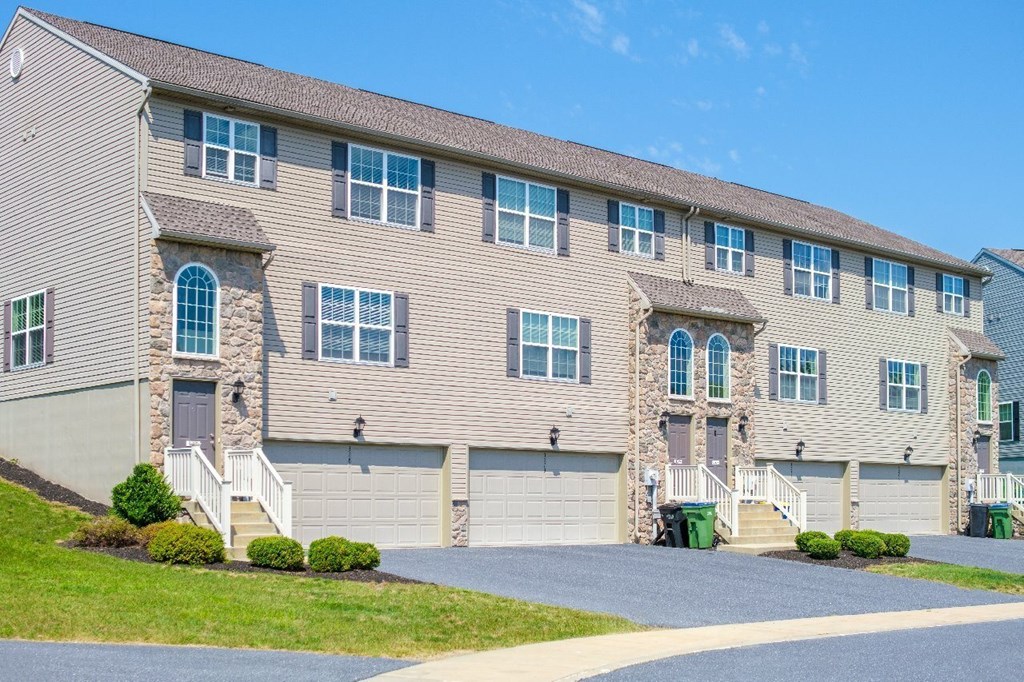 A large building with a grey facade and multiple windows.