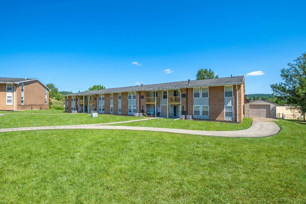 A row of houses with a green lawn in front.
